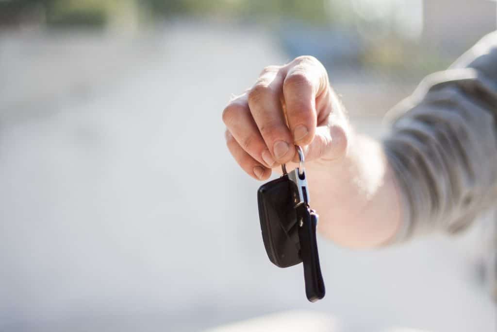 mão segurando a chave de um carro. financiar carro sem entrada pode ser uma opção para quem precisa de um carro