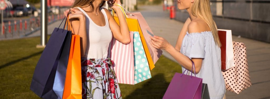 Mulheres com sacolas de compras nas mãos