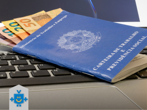 Descrição: Carteira de Trabalho com dinheiro sobre teclado, representando salário e empréstimo consignado CLT.